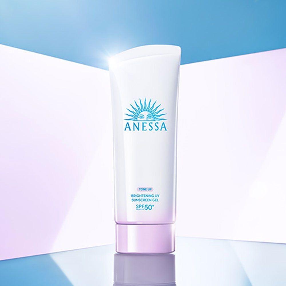 Anessa sunscreen gel bottle on a gradient blue and pink background